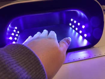reviewer's hand inside UV lamp