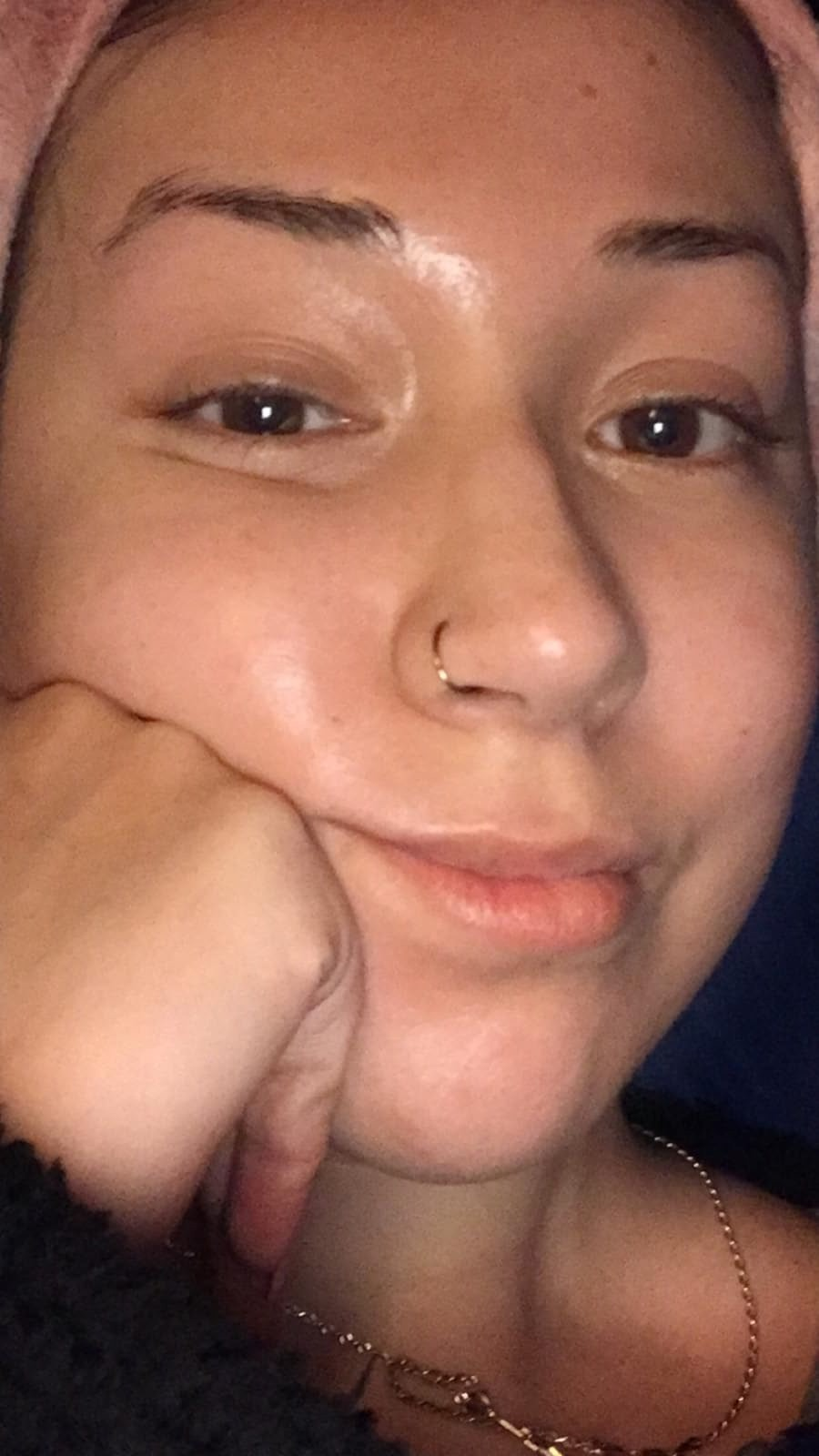 Person resting chin connected  hand, smiling somewhat  astatine  the camera