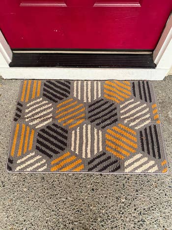 the orange and gray mat in front of a reviewer's red front door