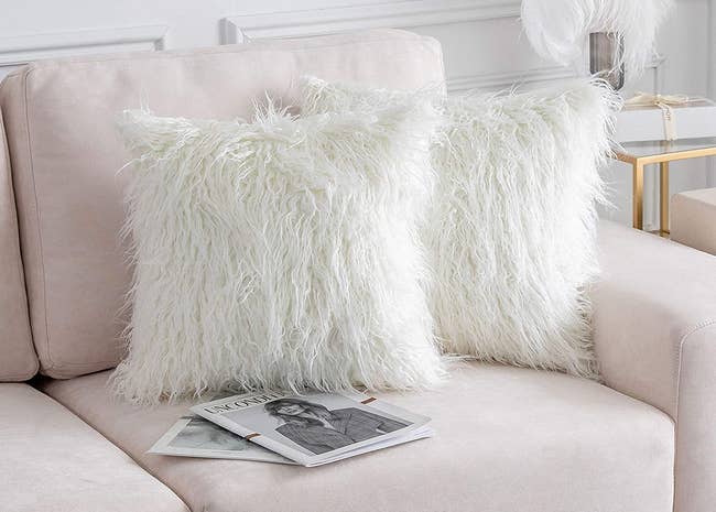 two pillows with the white faux fur cases