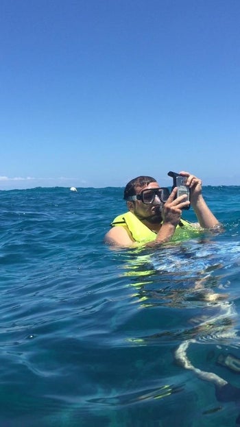 Reviewer snorkeling while holding a phone in this case