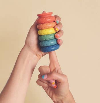 Model holding rainbow stack of buffer rings
