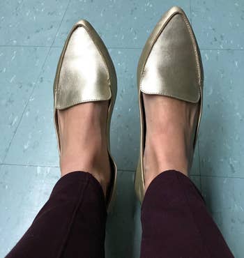reviewer wearing the gold loafers