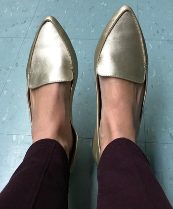 reviewer wearing the gold loafers