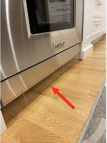 clear plastic blockers set up under a stove to prevent toys from going under