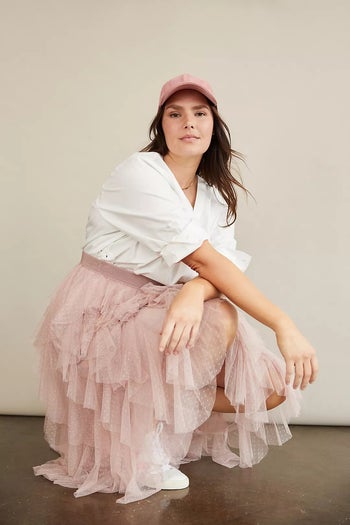 model in pale pink skirt in black with white shirt