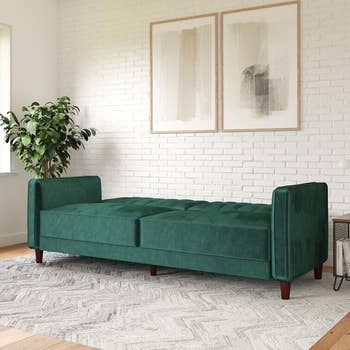 the green velvet sofa fully reclined into a sleeper position