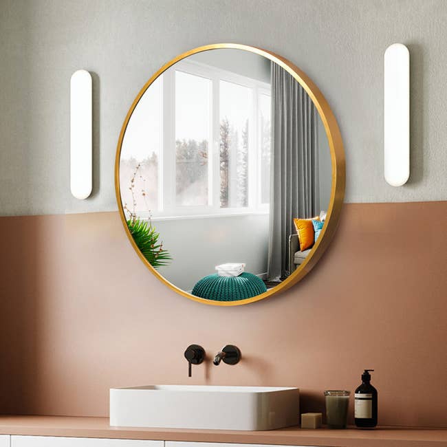 the large gold mirror over a bathroom sink