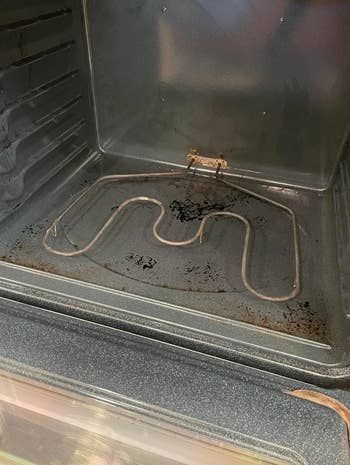 The representation  shows the bare  interior of an oven with a heating constituent   astatine  the bottom. The oven appears to beryllium  somewhat  dirty