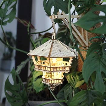 light up hanging tree house hanging from a monstera 