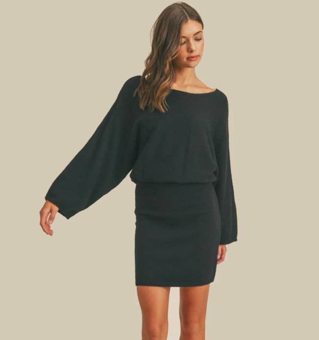 Model is wearing a black sweater dress