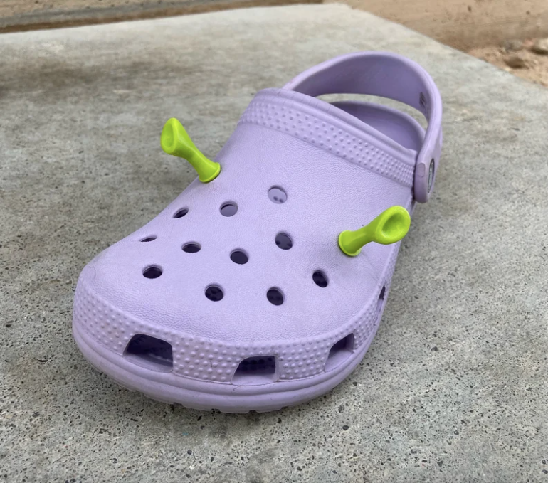crocs with green ogre ear charms in the holes