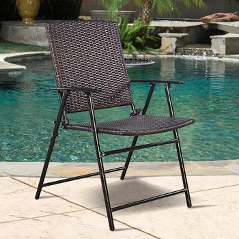 the brown wicker folding chair next to a pool