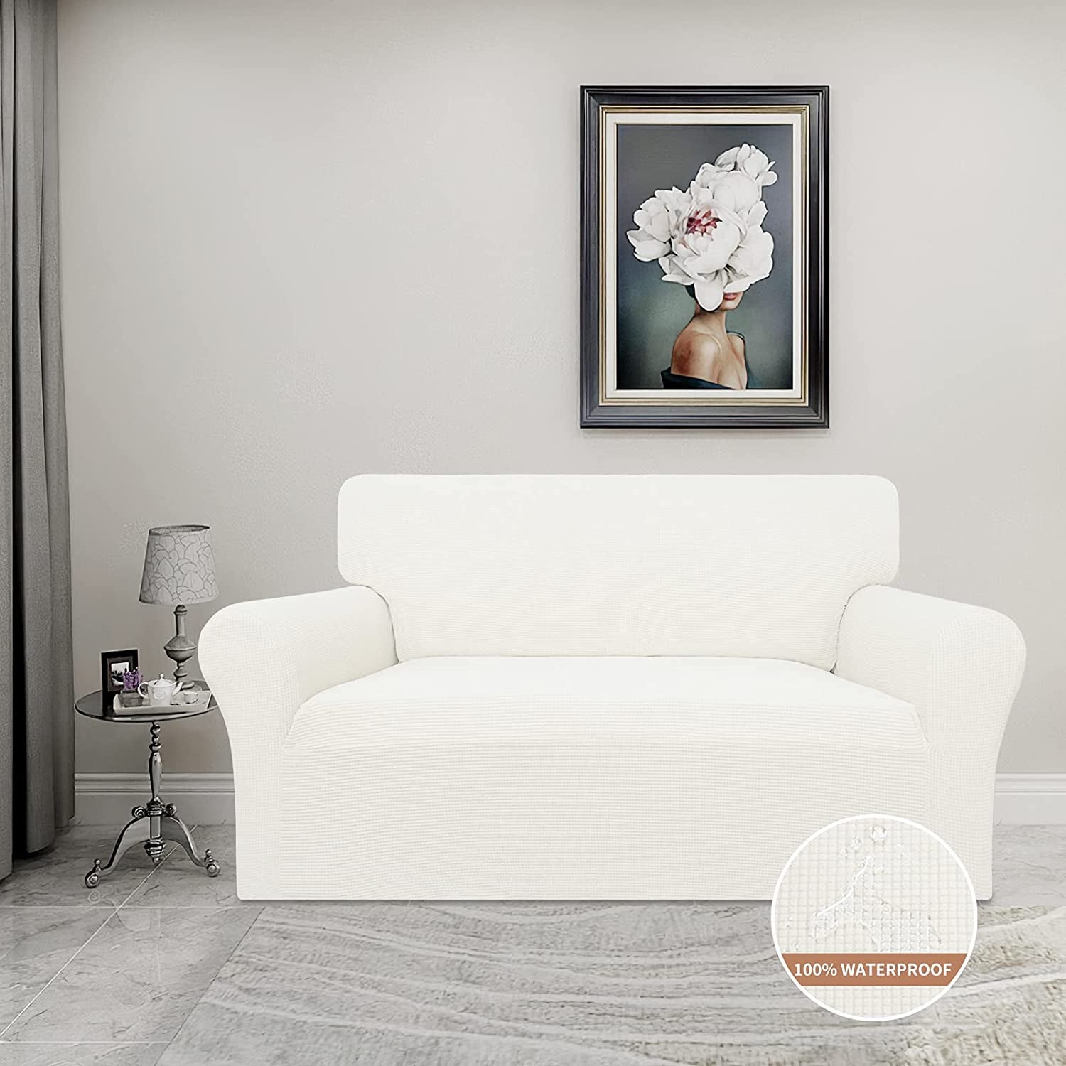 Couch with white grid pattern on a gray carpet next to glass side table with lamp and picture