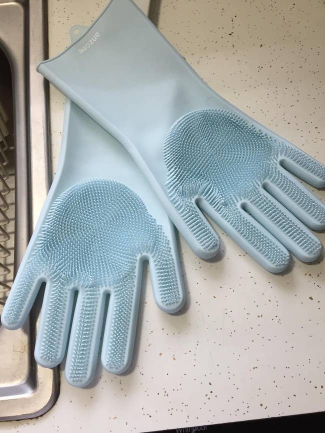 reviewer image of a pair of blue dishwashing gloves on a kitchen counter