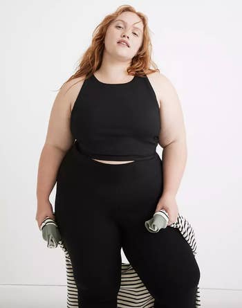 model wearing black crop top and leggings