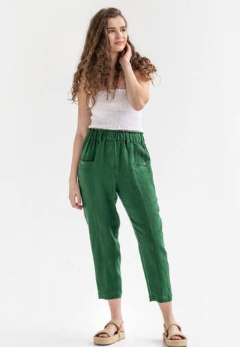 model wearing the green pants with a white top and sandals