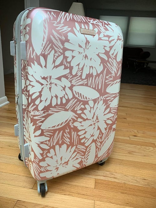 reviewer photo of pink and white floral exterior of suitcase