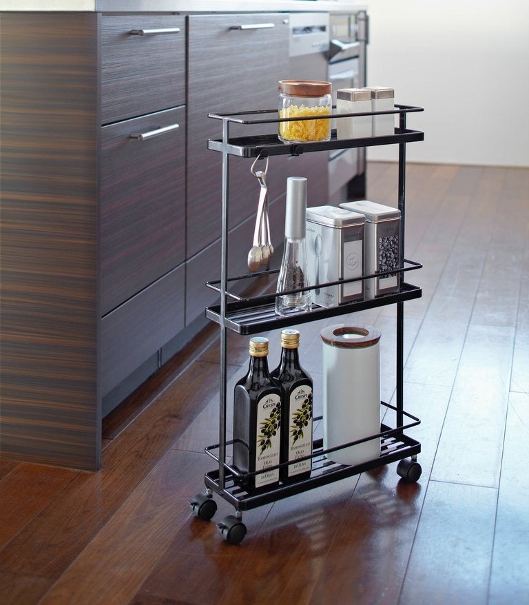 the black cart holding kitchen supplies