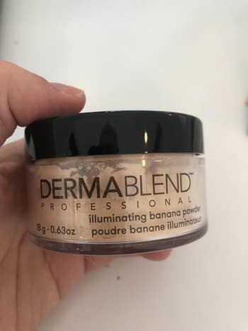 reviewer holding up the container of dermablend loose setting powder