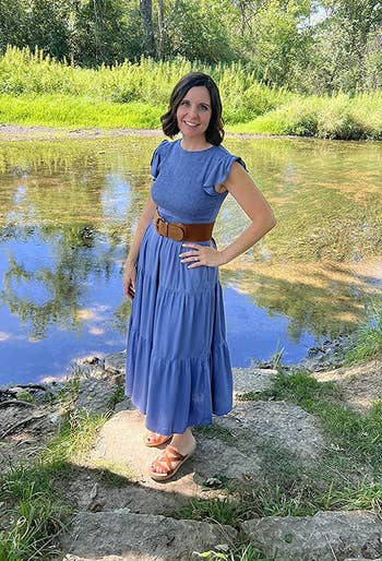 reviewer wearing the dress in blue posing by a pond