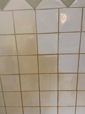 a reviewer's tiled bathroom partially cleaned by the pink stuff