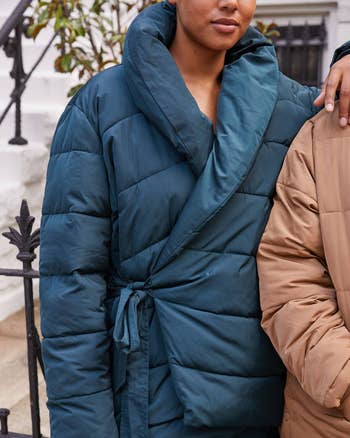 a model wearing the wrap coat in dark blue 