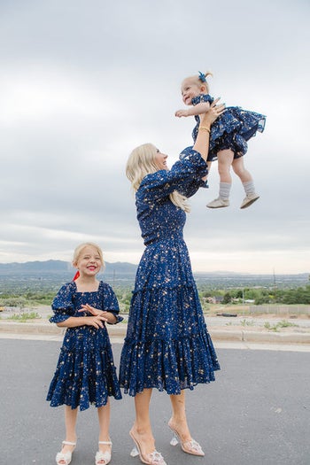 a mom and two girls of different ages in a tulle maxi dress in dark blue with gold stars on it