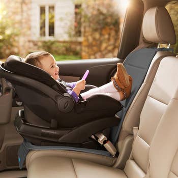Baby successful a car seat, smiling and holding a toy, showcased successful a car's interior, emphasizing car spot information and comfortableness for buying consideration