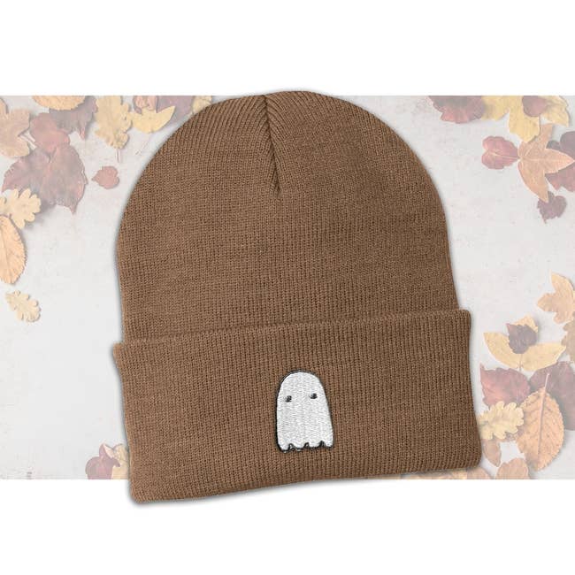 a brown beanie with a ghost patch on it