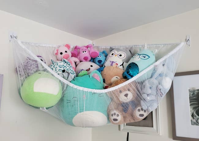 Reviewer photo of toy storage hammock full of stuffed animals
