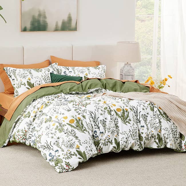 the yellow, green, and white floral bedding set with shams, a comforter, and sheets