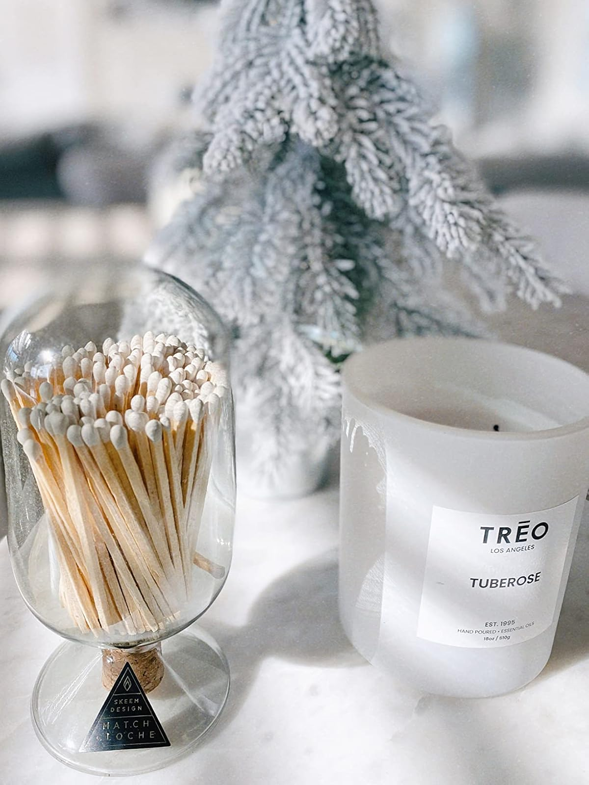 Candle and agelong  matches acceptable   adjacent  to a frosted decorative tree, showcasing a cozy and elegant location  décor point  suitable for acquisition  shopping