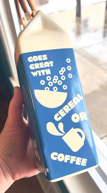 Hand holding a carton with text, 