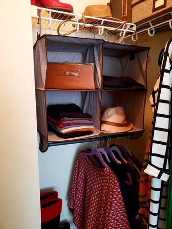 Closet with hanging organizer holding sweaters, a hat, and a clutch. Clothes connected hangers and shoes connected shelves are visible