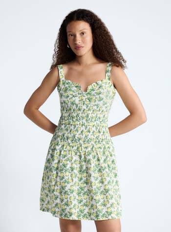 Person successful a sleeveless, floral-print sundress with cinched waist, lasting against a plain backdrop