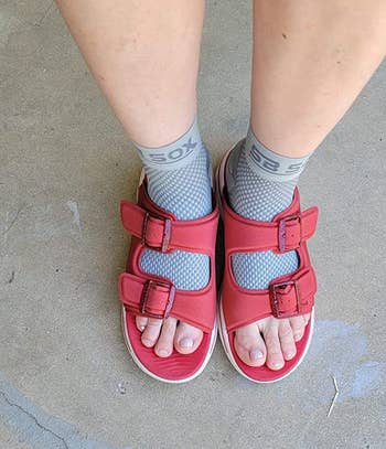 reviewer wearing gray compression socks with red sandals