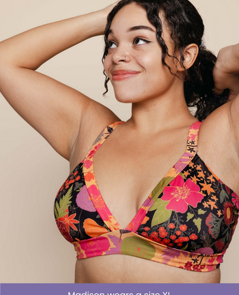a model poses in a floral V-neck swim top