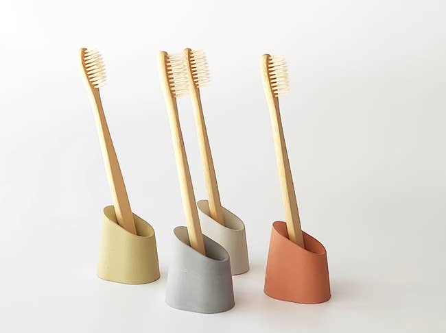 concrete toothbrush holders in yellow, beige, blue, and red
