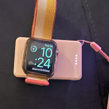 An apple watch charging on the charge pad 