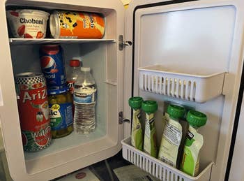 reviewer photo of the fridge filled with snacks and drinks