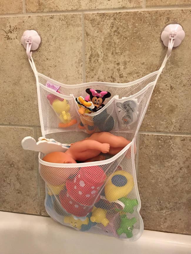 reviewer's toy holder on a bathroom wall with toys in it