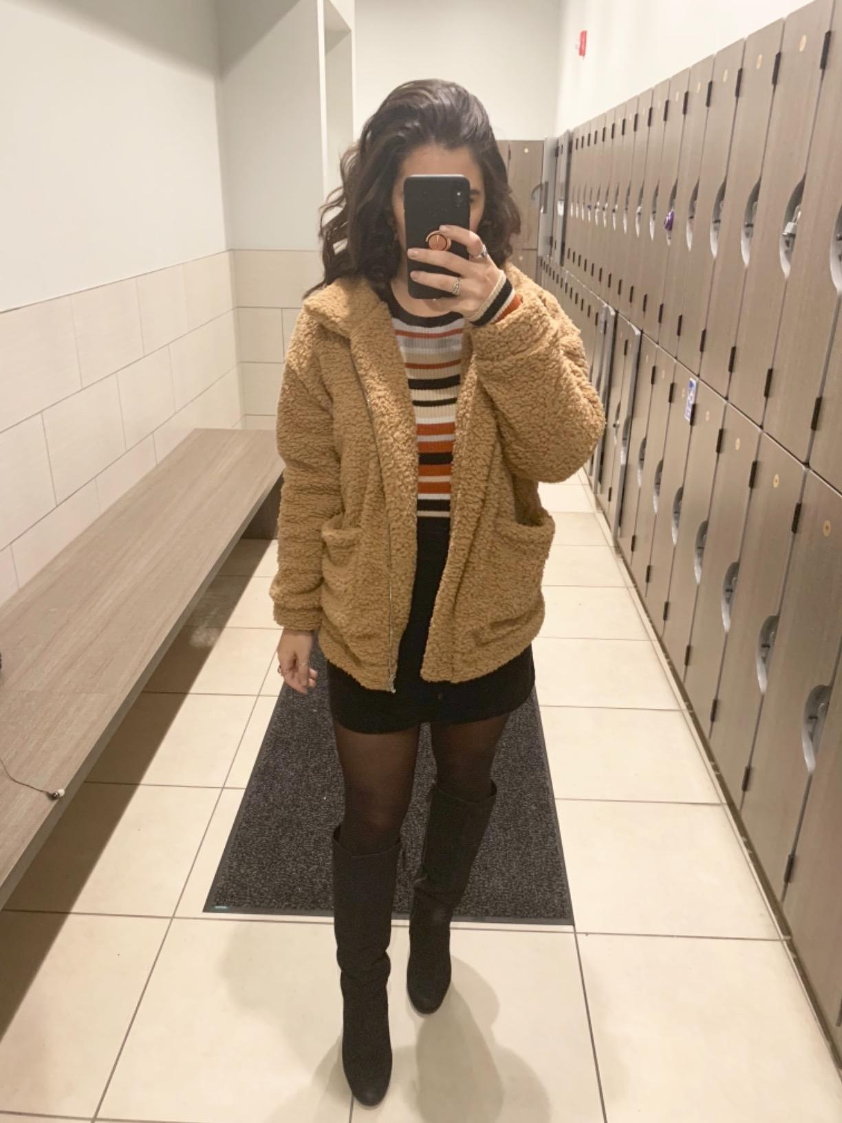 reviewer wearing the brown teddy coat with a skirt and tights