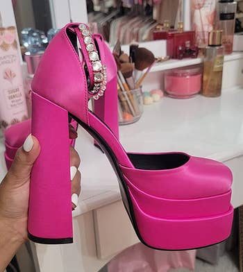 reviewer holding the bright pink shoes