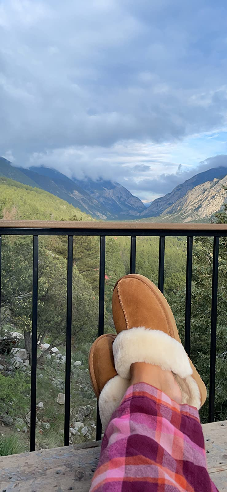 Reviewer wearing the chesnut colored slippers successful  beforehand   of a upland  backdrop