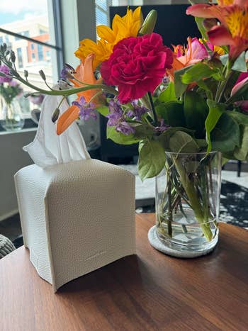 reviewer's achromatic faux leather insubstantial container screen adjacent to a vase of mixed flowers