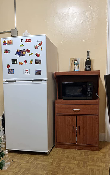 Reviewer image of product in dark wood shade with microwave in nook next to white fridge