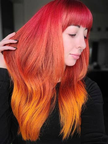 reviewer showing off red and orange ombre hair