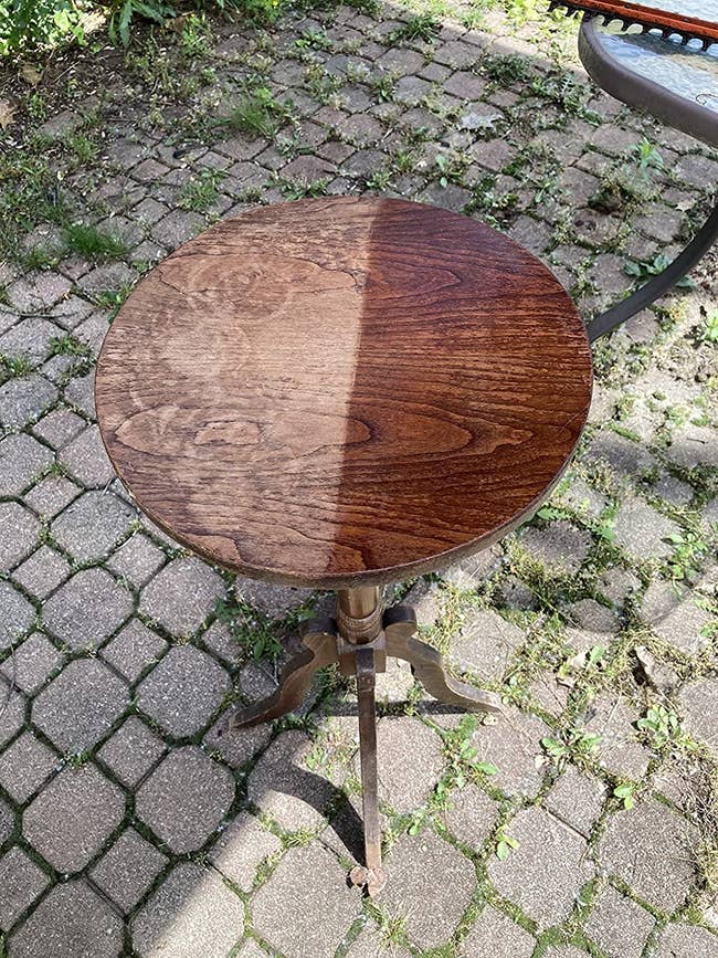 reviewer image of a round wooden table half conditioned and half distressed