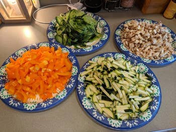  cucumbers, mushrooms, orangish  peppers, and zucchini, arranged connected  a room  countertop
